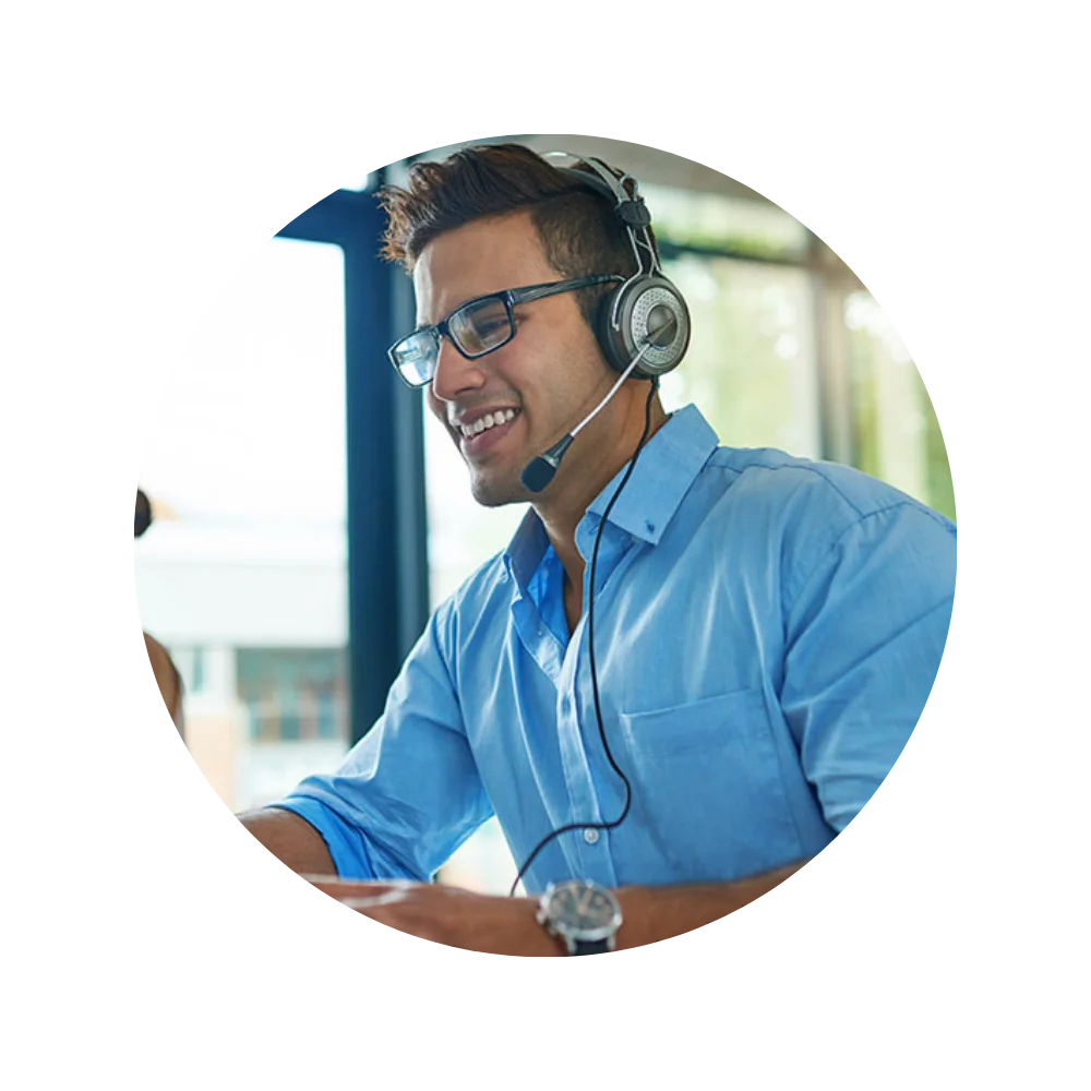 A man wearing a headset and smiling at his computer, engaged in an answering service for accountants