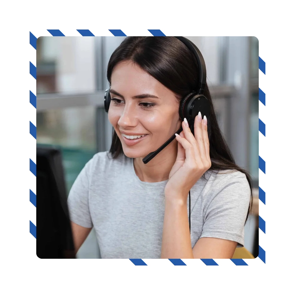 A woman wearing headphones sits in front of a computer, focused on her work or listening to audio content