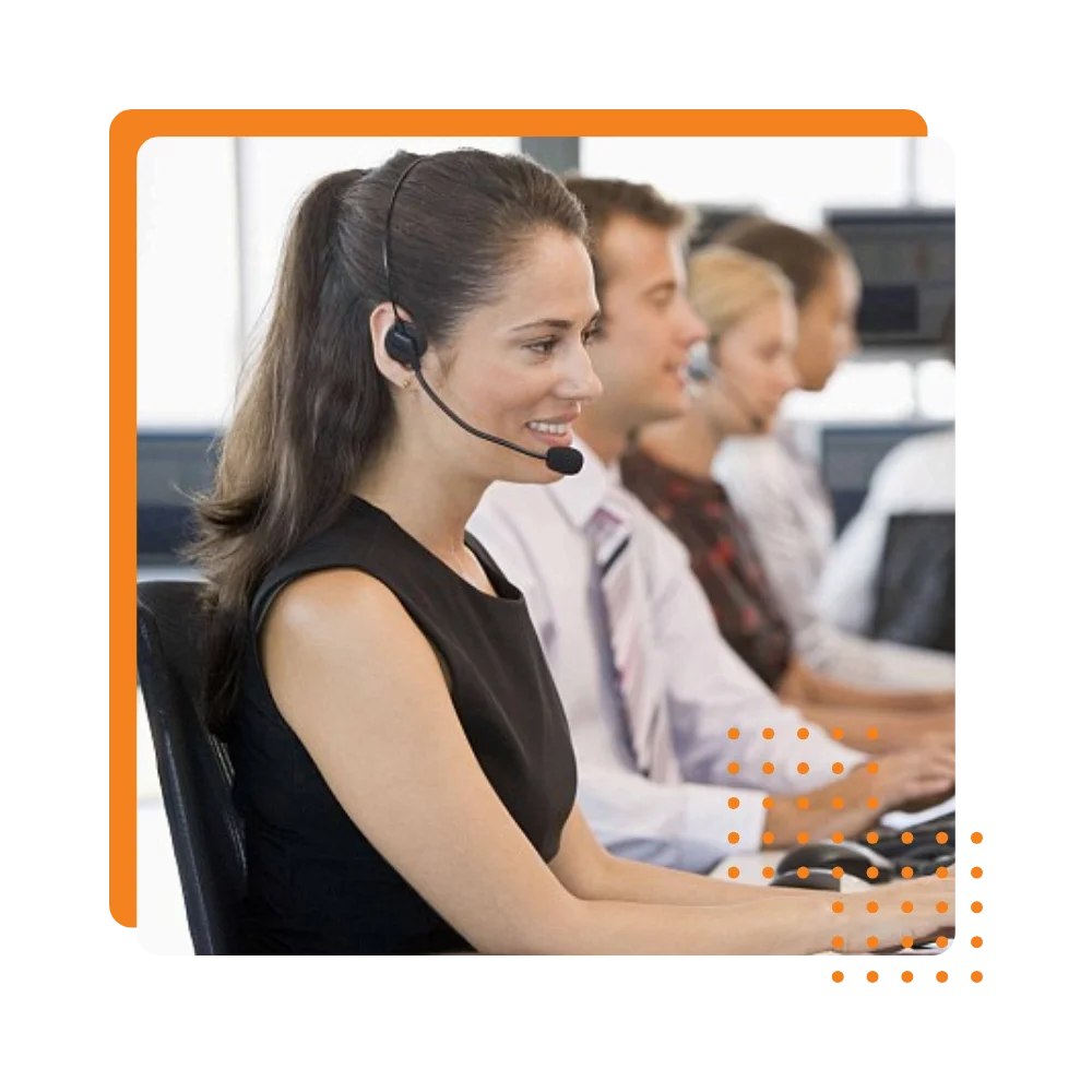 A woman wearing a headset, focused on her work in a busy call center environment