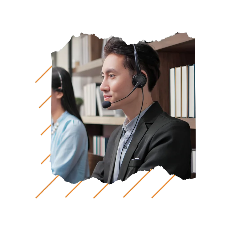 A man with a headset and a woman in a suit are engaged in a discussion, highlighting a collaborative work environment