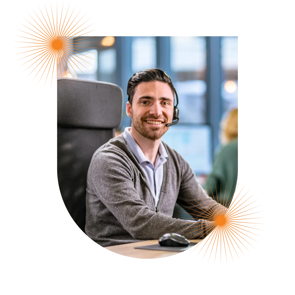 A smiling man in an office setting, representing a call center, with a focus on the role of a physician in healthcare