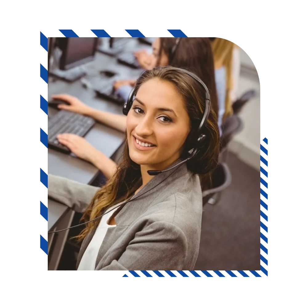 A female call center agent with a headset, engaged in a conversation, surrounded by colleagues