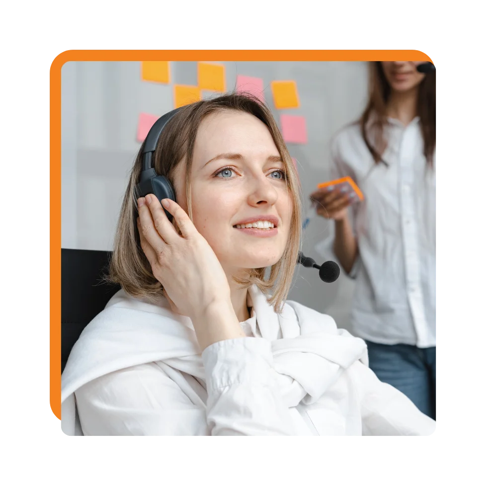 A woman in an office environment, utilizing a headset to communicate effectively during her tasks